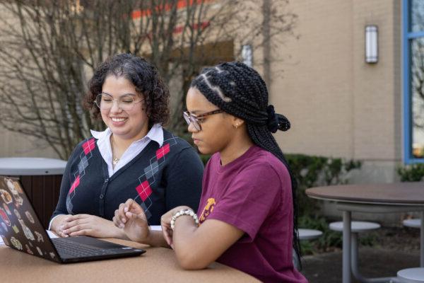 女学生在外面用笔记本电脑工作